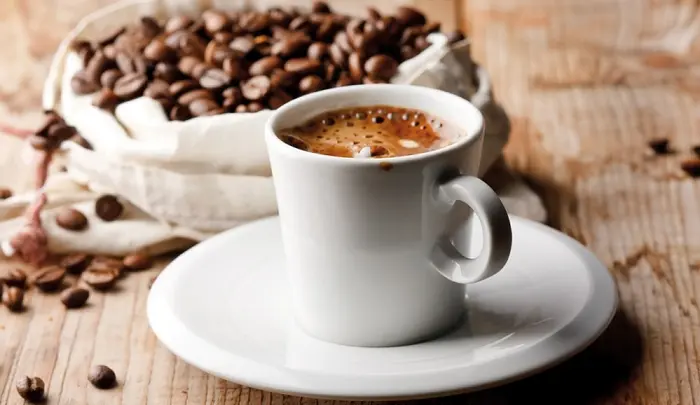 دانه های قهوه در کنار یک فنجان قهوه 78455221
